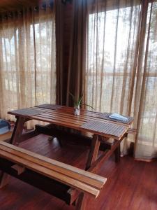 a wooden table with a potted plant on it in front of windows at The Palace Eco Cottage in Ella