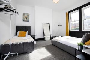 Low TeamにあるModern 3 Br Comfort On Faradayのベッド2台と鏡のある寝室