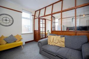 un salon avec un canapé et une horloge au mur dans l'établissement The 2 Bed Haven Perfect For Friends, Family Worker, à Gateshead