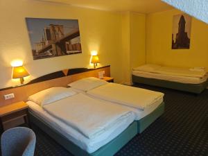 a hotel room with two beds and a chair at Hotel Flora in Hannover +59 photos