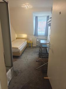 a small room with a bed and a desk at Hotel Flora in Hannover