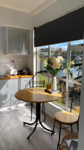 a kitchen with a table with a vase of flowers on it at Sunny flat 5 minute walk to town in Motueka