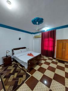 a bedroom with a bed and a red curtain at Blue Sky Apartments & Restaurant in Luxor