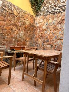 a wooden table and chairs in front of a stone wall at Casa Mira in Odemira