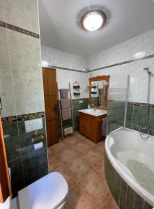 Un baño con bañera, inodoro y lavabo. en El Mirador de Carmina Habitaciones, en Frigiliana