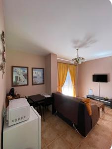 una sala de estar con un sofá y una mesa en El Mirador de Carmina Habitaciones, en Frigiliana