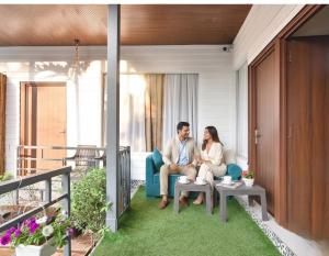 a man and woman sitting on a couch in a house at FabHotel Morjim Bliss in Morjim
