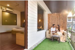 a man and a woman sitting in a living room at FabHotel Morjim Bliss in Morjim
