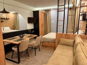 a room with a bed and a table and a couch at UN lux - Residence Hill in Kopaonik