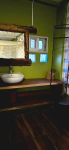 a bathroom with a sink and a green wall at African Tribe Hotel in Kampala +45 photos