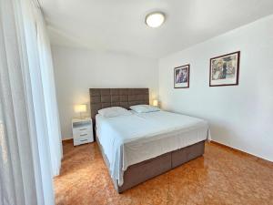 Un dormitorio con una cama y dos cuadros en la pared. en TOM M NV Apartment 250m from the beach, with terrace, en Novi Vinodolski
