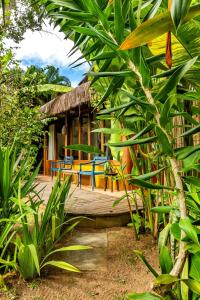 a wooden deck with blue chairs and a house at Casa Manga - 50m do Quadrado in Trancoso