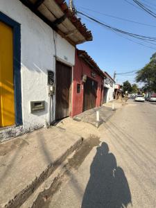 een schaduw van een persoon die over een straat loopt bij SUITE Yeshua in Paraty