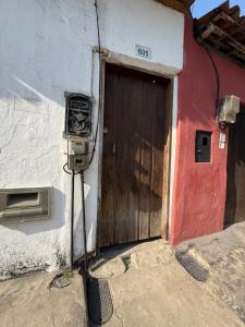 een deur naar een gebouw met een meter ernaast bij SUITE Yeshua in Paraty +2 foto's