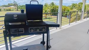 einen Grill auf einem Balkon mit Blick auf ein Feld in der Unterkunft Korah House in Saint Philip