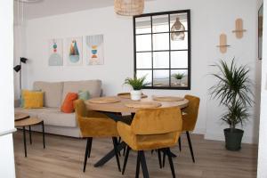 a dining room table with chairs and a couch at Sky New in Málaga +16 photos