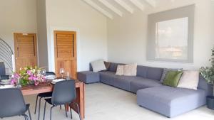 ein Wohnzimmer mit einem blauen Sofa und einem Tisch in der Unterkunft Korah House in Saint Philip