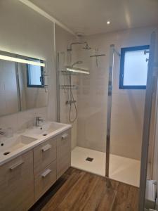 ein Badezimmer mit Dusche und Waschbecken in der Unterkunft Maison Les Dunes Bourgales in Gouville-sur-Mer