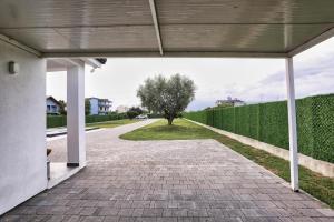 a walkway leading into a house with a tree at Holliday Villa in Tirana