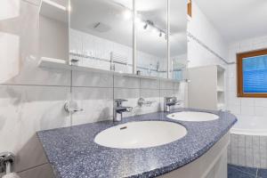 a bathroom with two sinks and a large mirror at Apart Jil-Marie in Samnaun +47 photos