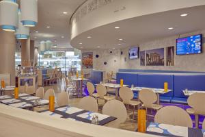 a restaurant with tables and chairs in a cafeteria at H2 Hotel Berlin-Alexanderplatz in Berlin