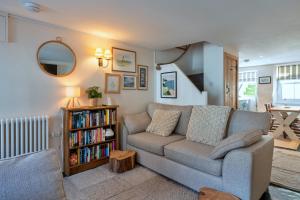 a living room with a couch and a book shelf at Finest Retreats - Cawsand Cottage in Cawsand
