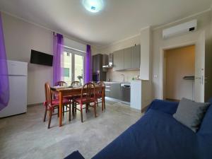 a living room with a table and chairs and a kitchen at 200m from Beach, New Central Apt, AC, WiFi in Loano