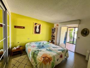 una camera da letto con un letto e una parete gialla di Maison vue mer a Banyuls-sur-Mer