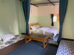 a small bedroom with a bed and a table at Purnata Farm and Arts Residency in Pokhara