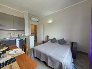 a bedroom with a bed and a kitchen with a table at 200m from Beach, New Central Apt, AC, WiFi in Loano