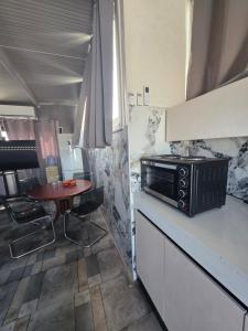 a kitchen with a small table and a microwave at Costas Court in Limassol +12 photos
