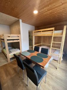 a room with a table and chairs and bunk beds at KEARL, studio neuf soleil et détente in Les Gets +1 photo