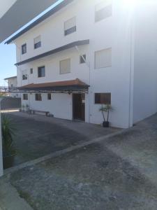 a white building with a garage and a driveway at SOBREIRO - Sobreiro Alojamento - Grijó in Grijó
