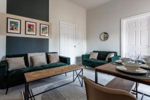 サンダーランドにあるThe Sunderland Spot Family & Work Readyの緑のソファとテーブルのあるリビングルーム