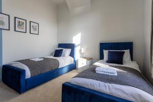 サンダーランドにあるThe Sunderland Spot Family & Work Readyの青いヘッドボードが付いたベッドが2つある寝室