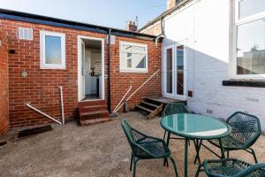 サンダーランドにあるThe Sunderland Spot Family & Work Readyのレンガ造りの建物の隣にパティオ(テーブル、椅子付)