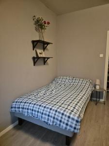 a bedroom with a bed and a shelf with flowers on the wall at Central Studio in Vaasa with Free Parking in Vaasa