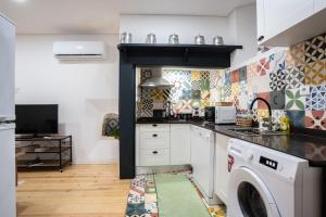 a kitchen with a washer and dryer at Casas da Ferraria by 4U Alojamento in Abrantes