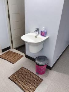a bathroom with a sink and a trash can at Tamil Homestay with Kitchen in Thanjāvūr +8 photos