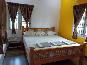 a bedroom with a wooden bed with two pillows on it at Tamil Homestay with Kitchen in Thanjāvūr