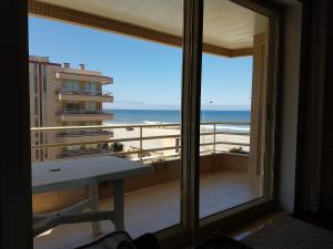 a view of the beach from a room with a window at Facing the Sea in Furadouro