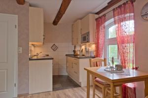 a kitchen with a table and a dining room at Seepferdchen in Stinteck