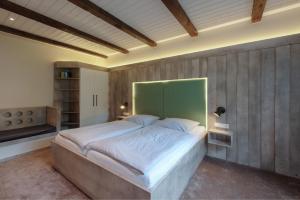 a bedroom with a large bed with a green headboard at Wattenläuper in Stinteck