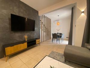 a living room with a flat screen tv on a wall at Le Dauphin Villa 3 Bedroom 5min Walk to Beach - LB2 in Flic-en-Flac