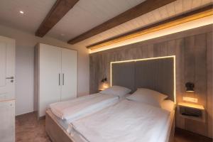 a bedroom with a large bed with a headboard at Deichgraf in Stinteck