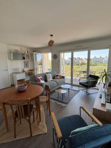 a living room with a couch and a table at Les Cavaliers in Cabourg