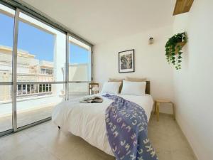 a bedroom with a bed and a large window at Sea View Duplex On Frishman Beach 2Bdr apt and BBQ in Tel Aviv