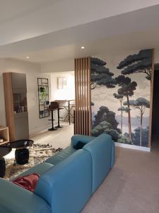 a living room with a blue couch and a painting on the wall at Red carpet - Townhouse, 2 bedrooms, 2 bathrooms in Saint-Marcel
