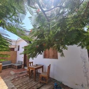 a patio with a table and chairs and a tree at Cozy 2 bedrooms in eel gardens, Dahab in Dahab