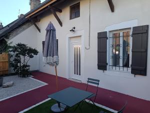 a patio with a table in front of a house at Red carpet - Townhouse, 2 bedrooms, 2 bathrooms in Saint-Marcel